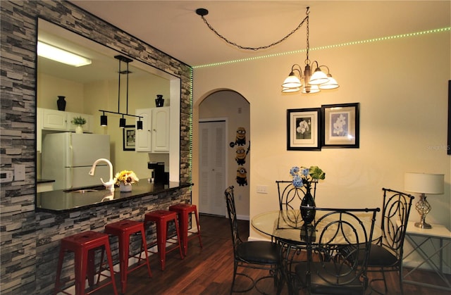 dining space featuring a chandelier, dark hardwood / wood-style floors, and sink