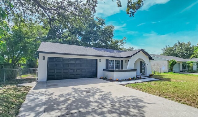 ranch-style home with a garage and a front lawn