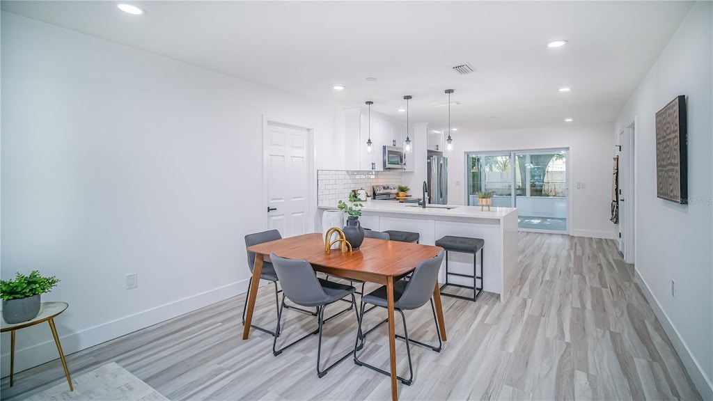 dining area featuring sink and light hardwood / wood-style floors