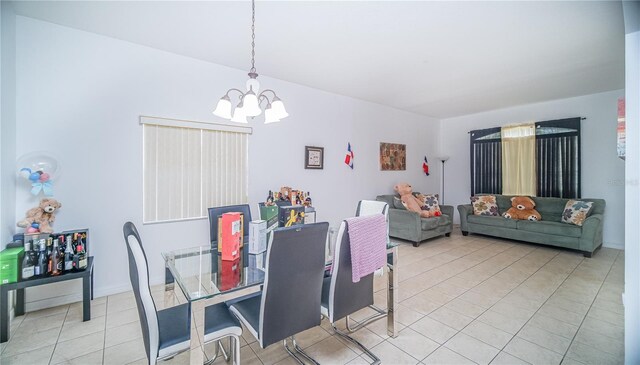 dining area featuring tile patterned floors and a chandelier