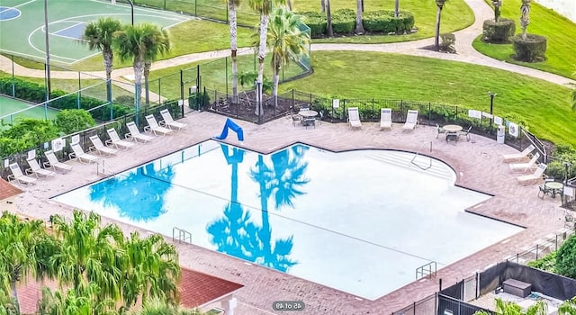 view of pool with basketball court and a lawn