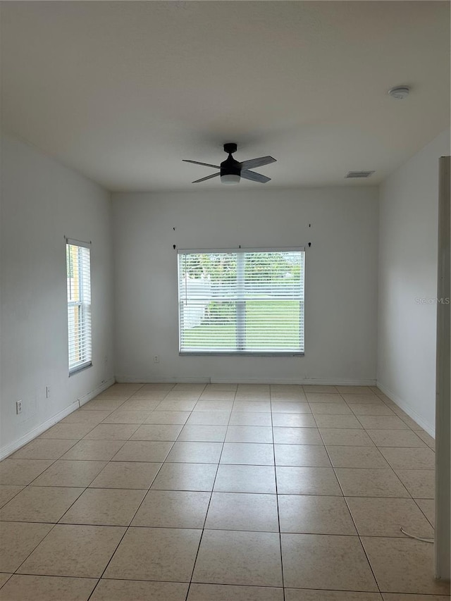 tiled spare room with ceiling fan