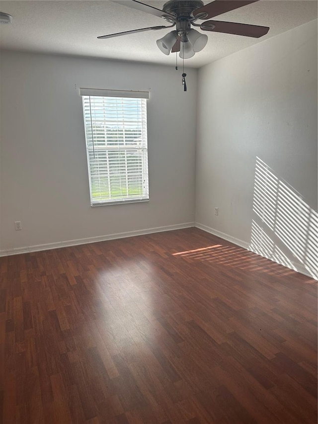 empty room with ceiling fan and dark wood-type flooring