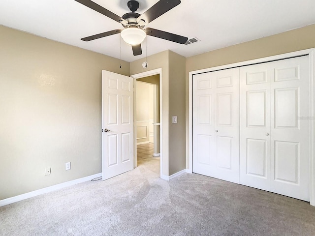 unfurnished bedroom featuring ceiling fan, a closet, and light carpet