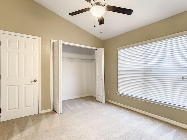 unfurnished bedroom with lofted ceiling, light colored carpet, ceiling fan, and a closet