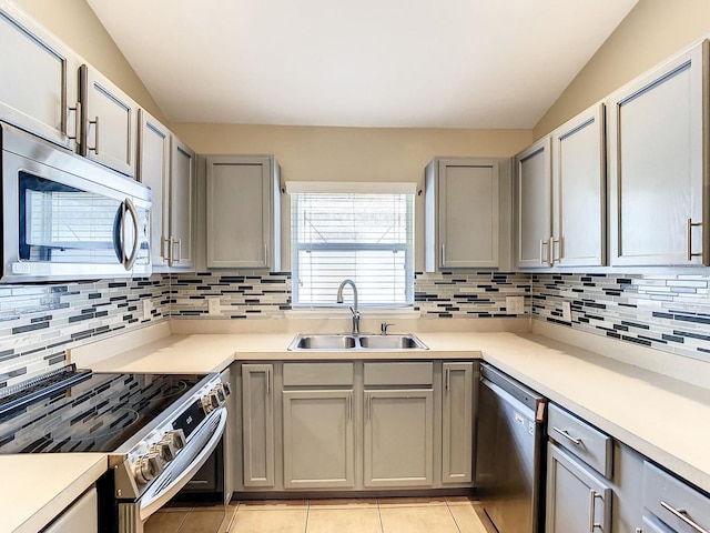 kitchen with sink, light tile patterned floors, decorative backsplash, and appliances with stainless steel finishes