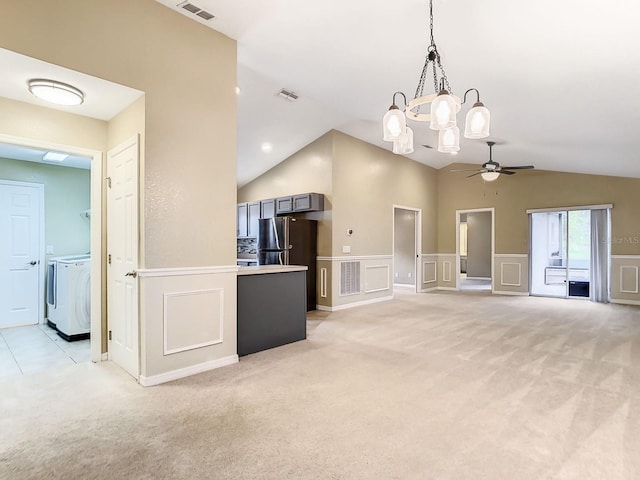 kitchen featuring decorative light fixtures, lofted ceiling, ceiling fan, independent washer and dryer, and light carpet