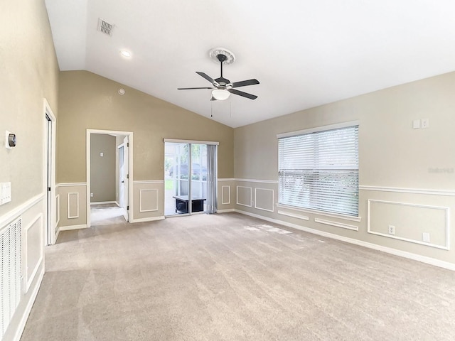 carpeted spare room featuring vaulted ceiling and ceiling fan