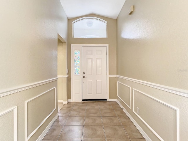 entryway with tile patterned flooring and lofted ceiling