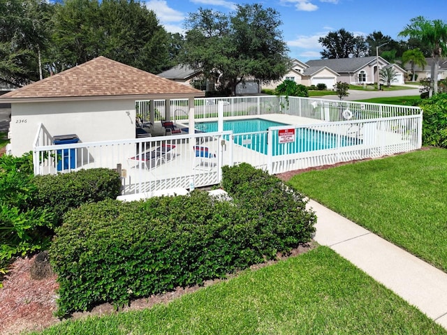 view of swimming pool with a lawn