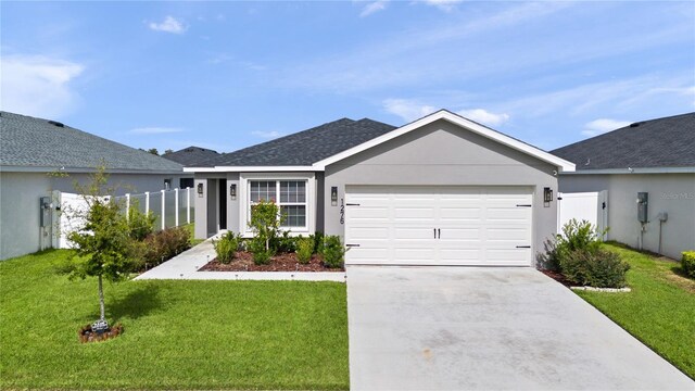 single story home featuring a garage and a front yard