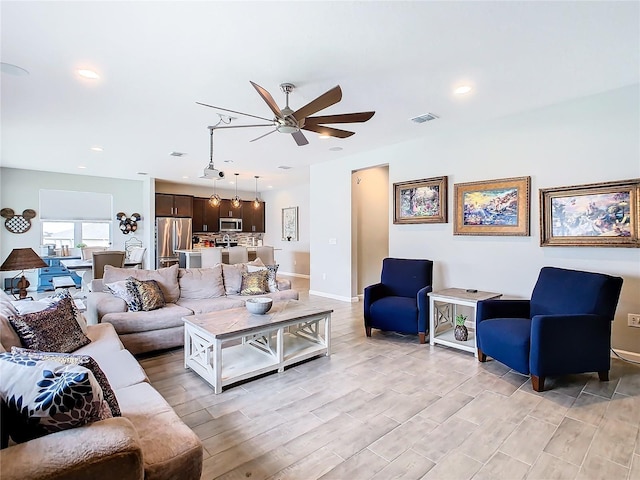 living area with recessed lighting, visible vents, light wood-style flooring, a ceiling fan, and baseboards