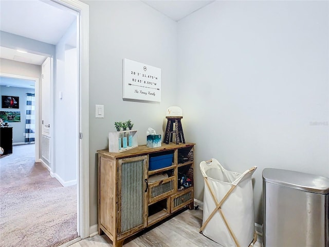 interior space featuring carpet, baseboards, and wood finished floors