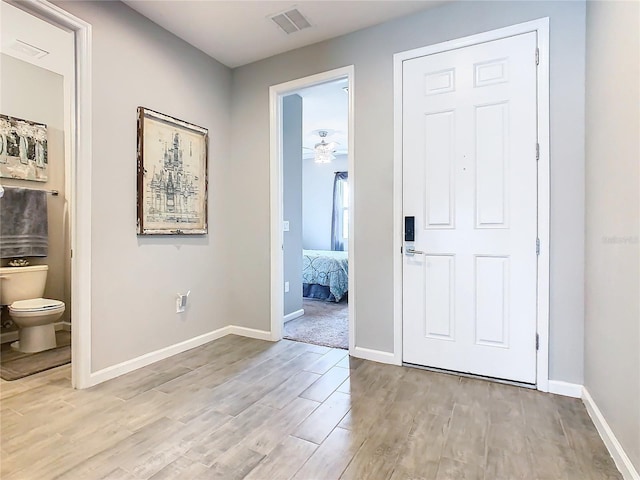 foyer with baseboards, visible vents, ceiling fan, and light wood finished floors