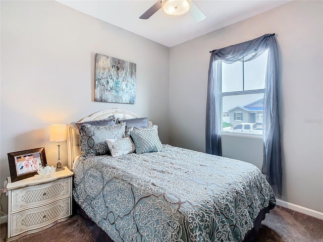 bedroom with dark colored carpet, ceiling fan, and baseboards