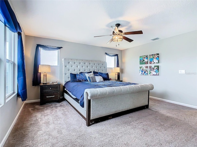 carpeted bedroom featuring ceiling fan, visible vents, and baseboards