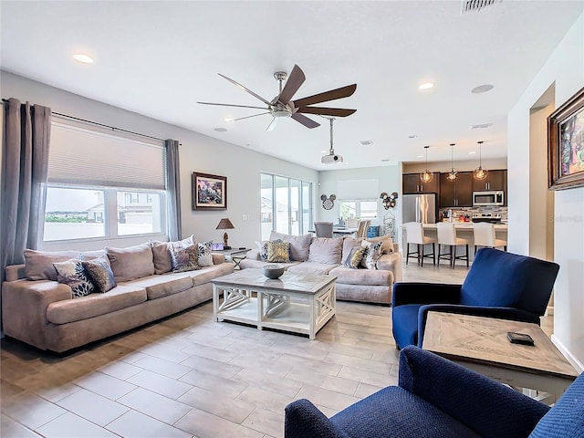 living room with ceiling fan, visible vents, and recessed lighting