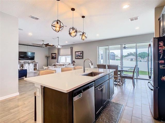 kitchen featuring open floor plan, stainless steel appliances, a sink, and visible vents