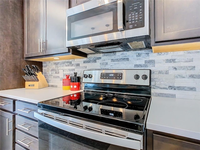 kitchen featuring stainless steel appliances, light countertops, and tasteful backsplash