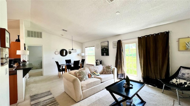 living room with vaulted ceiling, light carpet, and a textured ceiling