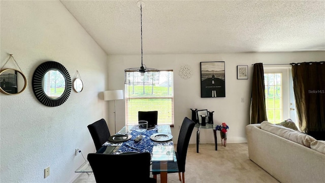 dining space with ceiling fan, a textured ceiling, and light carpet