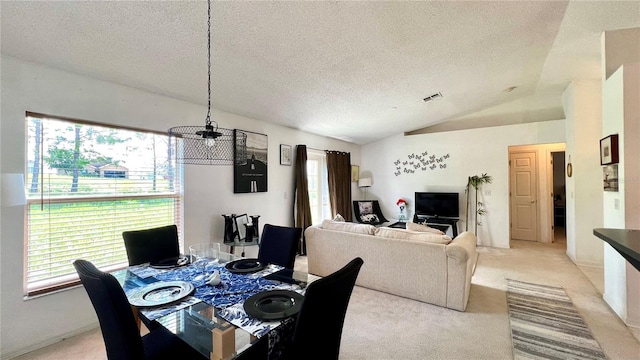 dining room featuring vaulted ceiling, light colored carpet, and plenty of natural light