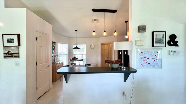 kitchen with kitchen peninsula, a kitchen breakfast bar, and decorative light fixtures