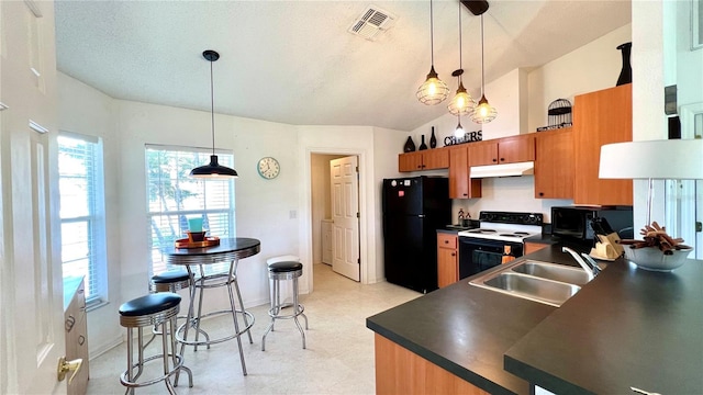 kitchen featuring electric stove, sink, black fridge, decorative light fixtures, and vaulted ceiling