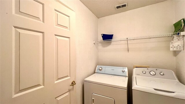 laundry area featuring independent washer and dryer and a textured ceiling