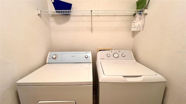 clothes washing area with washing machine and dryer