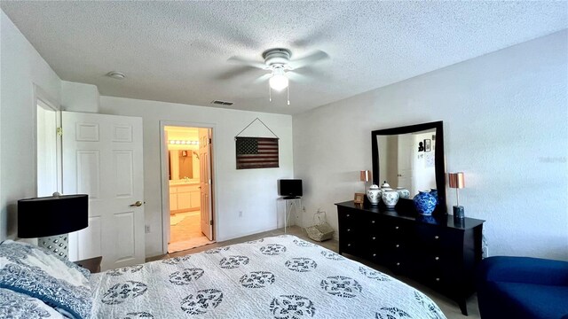 tiled bedroom featuring connected bathroom, ceiling fan, and a textured ceiling