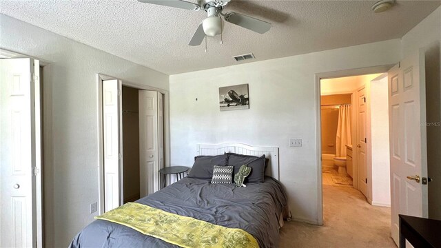 carpeted bedroom featuring ceiling fan and a textured ceiling