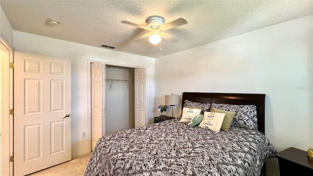 carpeted bedroom with a textured ceiling, a closet, and ceiling fan