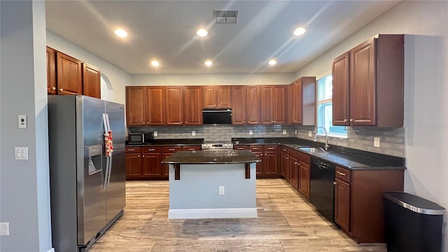 kitchen featuring stainless steel appliances, a center island, sink, and decorative backsplash