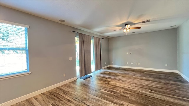 empty room with hardwood / wood-style floors and ceiling fan