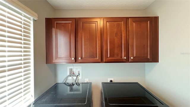 laundry room featuring electric dryer hookup, hookup for a washing machine, cabinets, and a textured ceiling