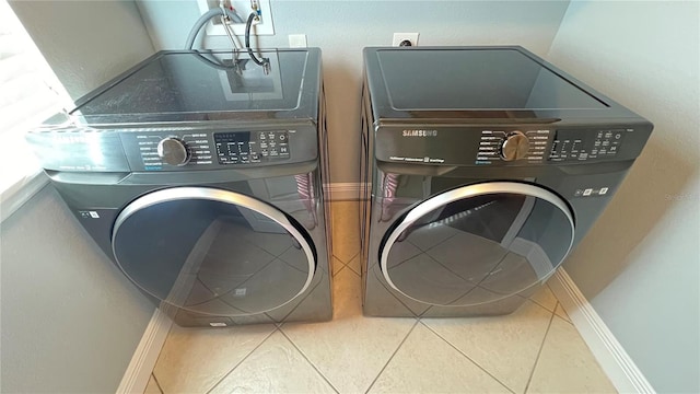 clothes washing area featuring separate washer and dryer and tile patterned floors