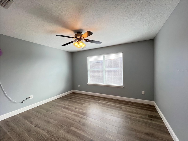 unfurnished room featuring dark hardwood / wood-style flooring and a textured ceiling