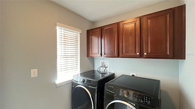 clothes washing area with cabinets and washer and dryer