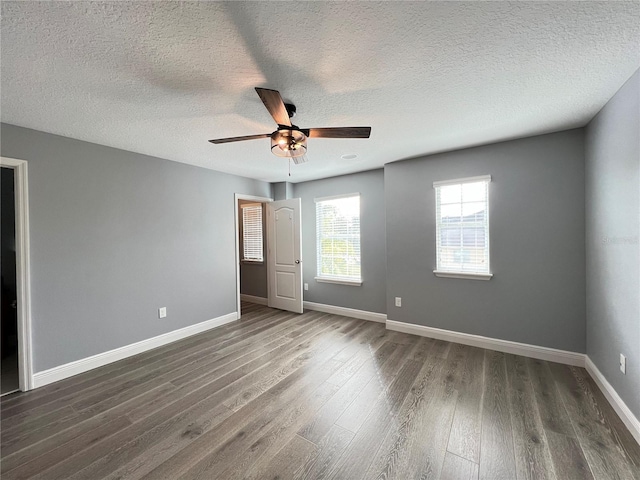 unfurnished bedroom featuring dark hardwood / wood-style flooring, a textured ceiling, and ceiling fan