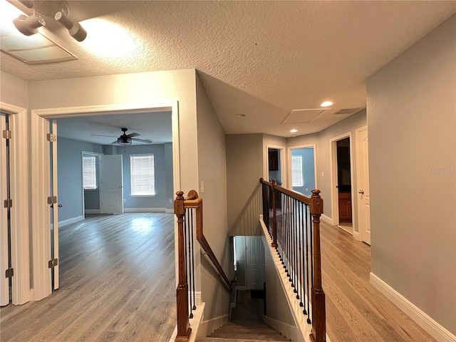 corridor with light hardwood / wood-style flooring and a textured ceiling