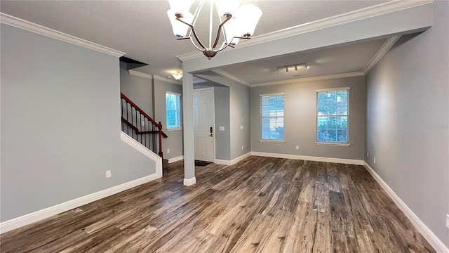 unfurnished dining area featuring ornamental molding, a chandelier, hardwood / wood-style floors, and a textured ceiling