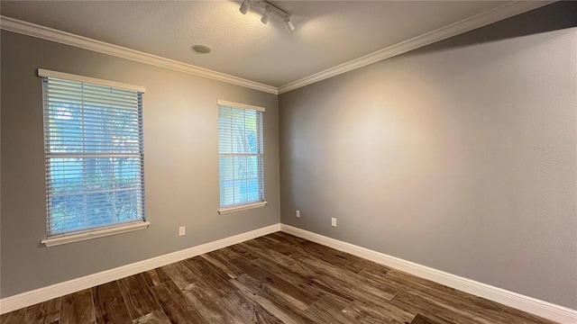 unfurnished room featuring crown molding, dark wood-type flooring, and rail lighting