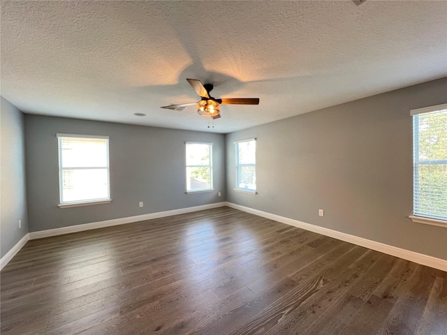 unfurnished room featuring dark wood-type flooring, ceiling fan, and plenty of natural light