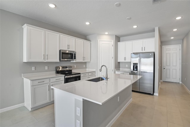 kitchen featuring stainless steel appliances, white cabinetry, sink, and a center island with sink