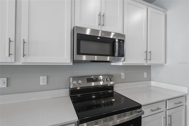 kitchen with stainless steel appliances, white cabinetry, and tasteful backsplash