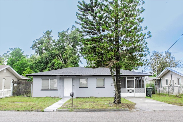 view of front facade featuring a sunroom and a front yard