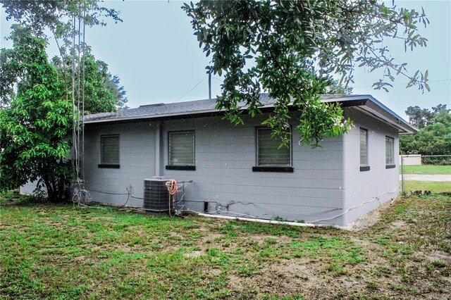 view of home's exterior with central AC and a lawn