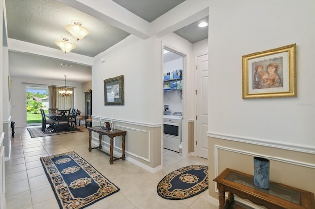 hallway with light tile patterned flooring and a chandelier