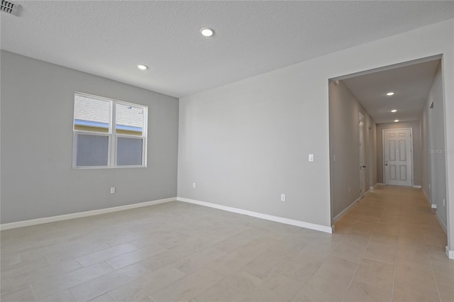 unfurnished room featuring a textured ceiling